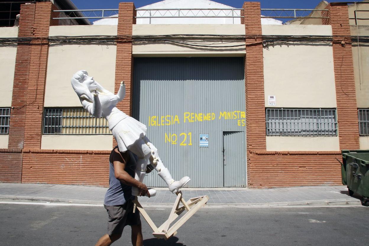 Operario de un taller transportando un ninot en Ciudad Fallera. irene marsilla