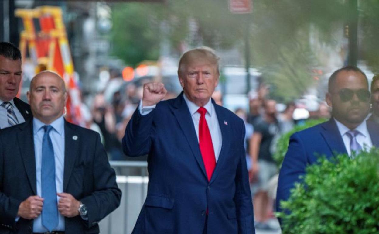 El expresidente Donald Trump levanta el puño en señal de victoria al salir de su edificio para acudir a la Fiscalía de Nueva York