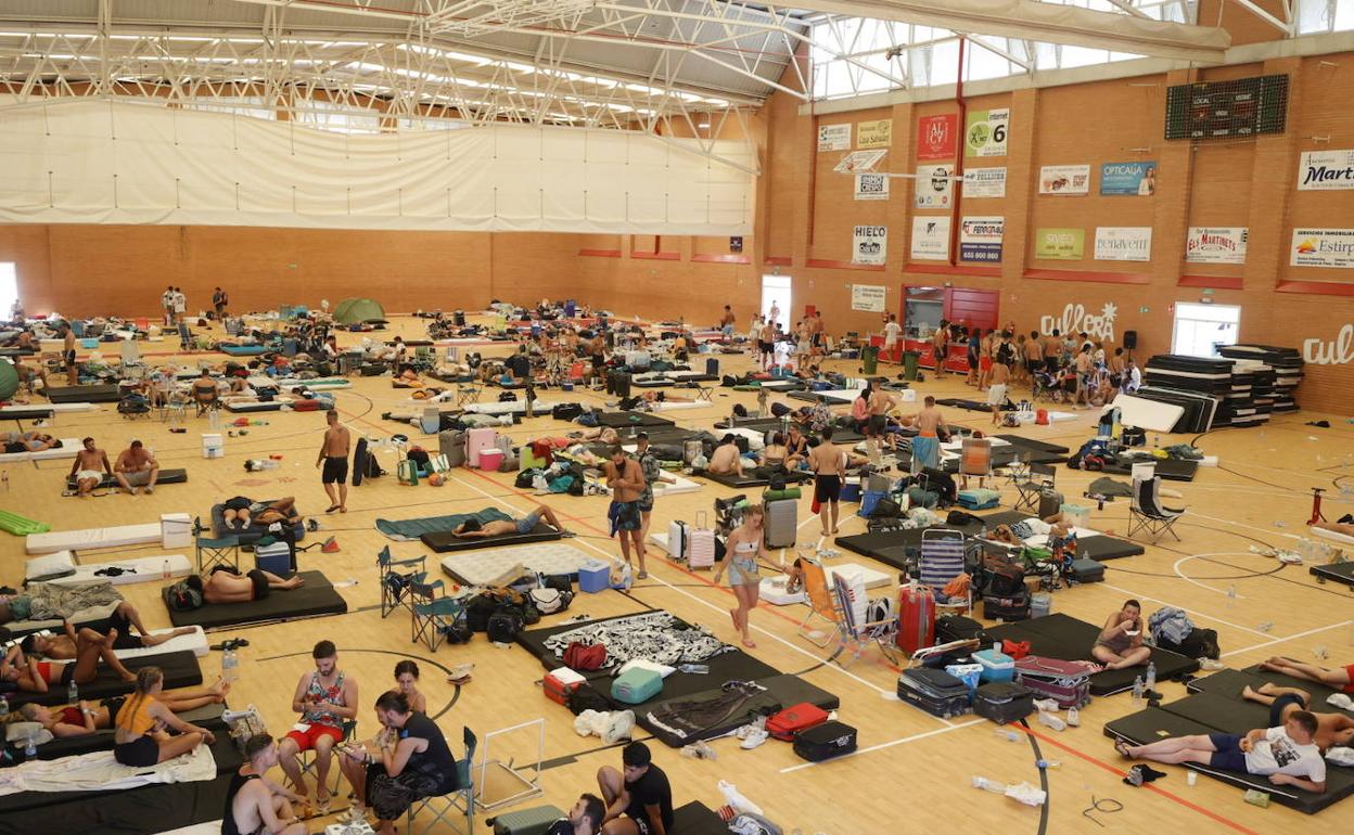 Jóvenes duermen en el polideportivo de Cullera.