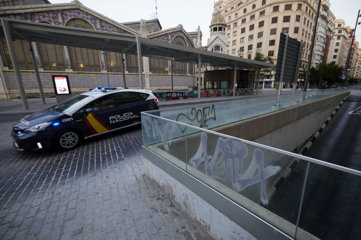 Un coche policial pasa junto a la rampa del parking del Mercat, en la plaza Ciudad de Brujas. iván arlandis