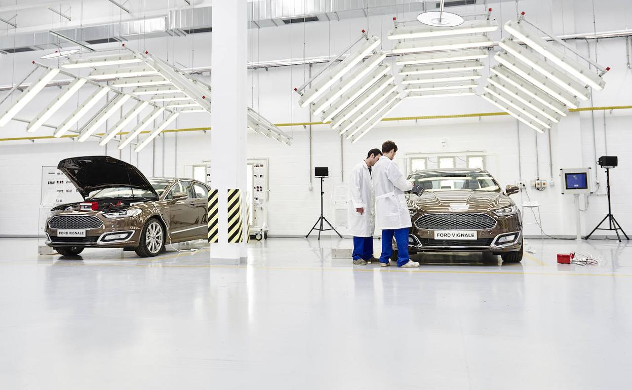 Dos ténicos revisan dos vehículso en las instalaciones de Ford. 