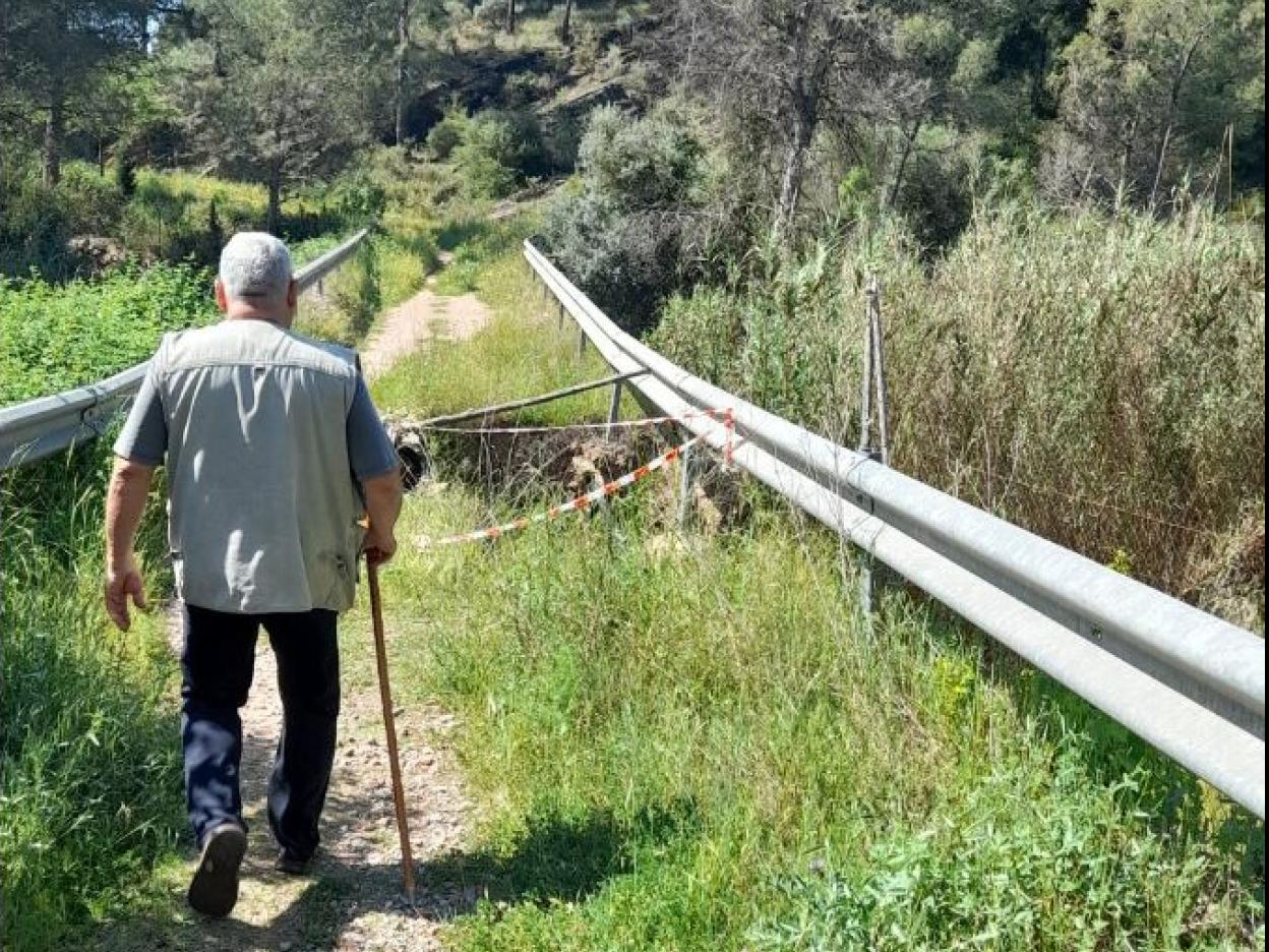 Un vecino recorre el peligroso puente sobre el barranco del Carraixet. Manuel García