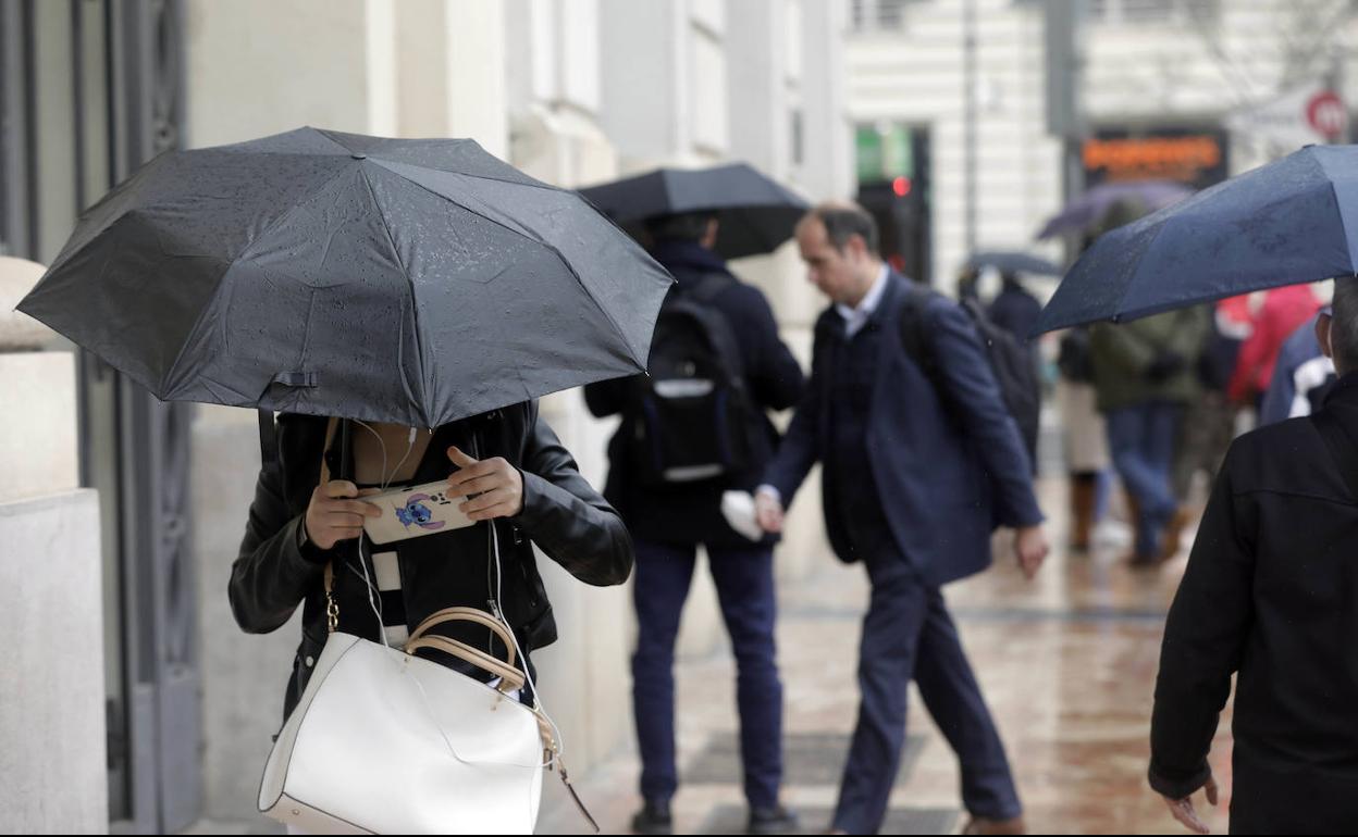 Varias personas pasean por Valencia durante un día lluvioso