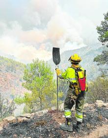 Imagen secundaria 2 - 1.- Los cuatro bomberos forestales de la brigada de Zarra que pasaron junto a la bomba de la Guerra Civil. | 2.- Clara Nora Ruiz Vela, con un batefuegos en su mano, divisa una columna de humo.