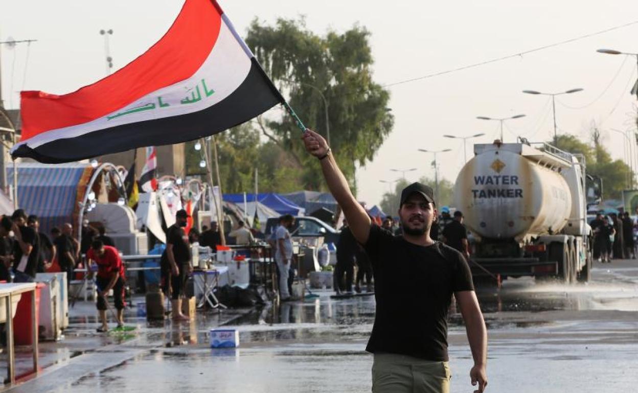 Un seguidor del clérigo Muqtada al-Sadr ondea la bandera de Irak en una protesta. 