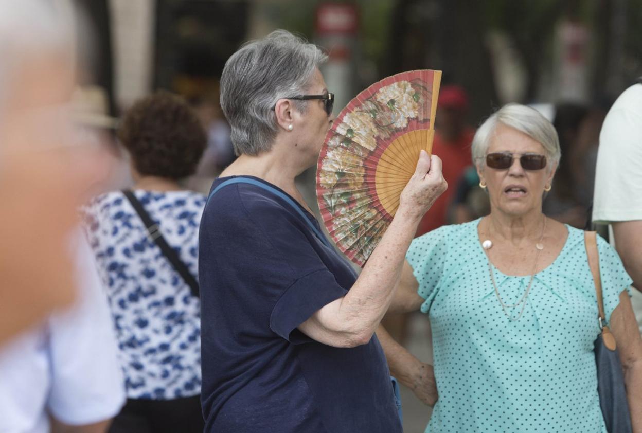 Una viandante se sofoca el calor
con un abanico en Valencia. damián torres