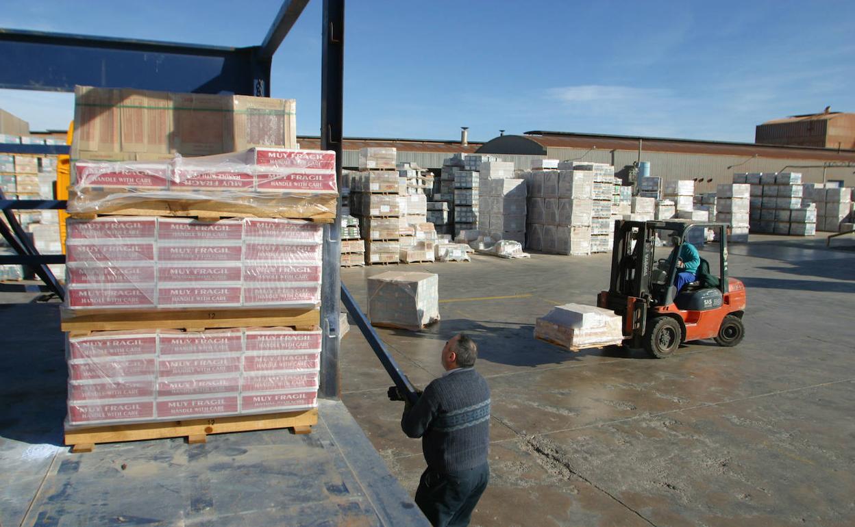 Dos empleados de una fábrica de Castellón cargan un camión. 