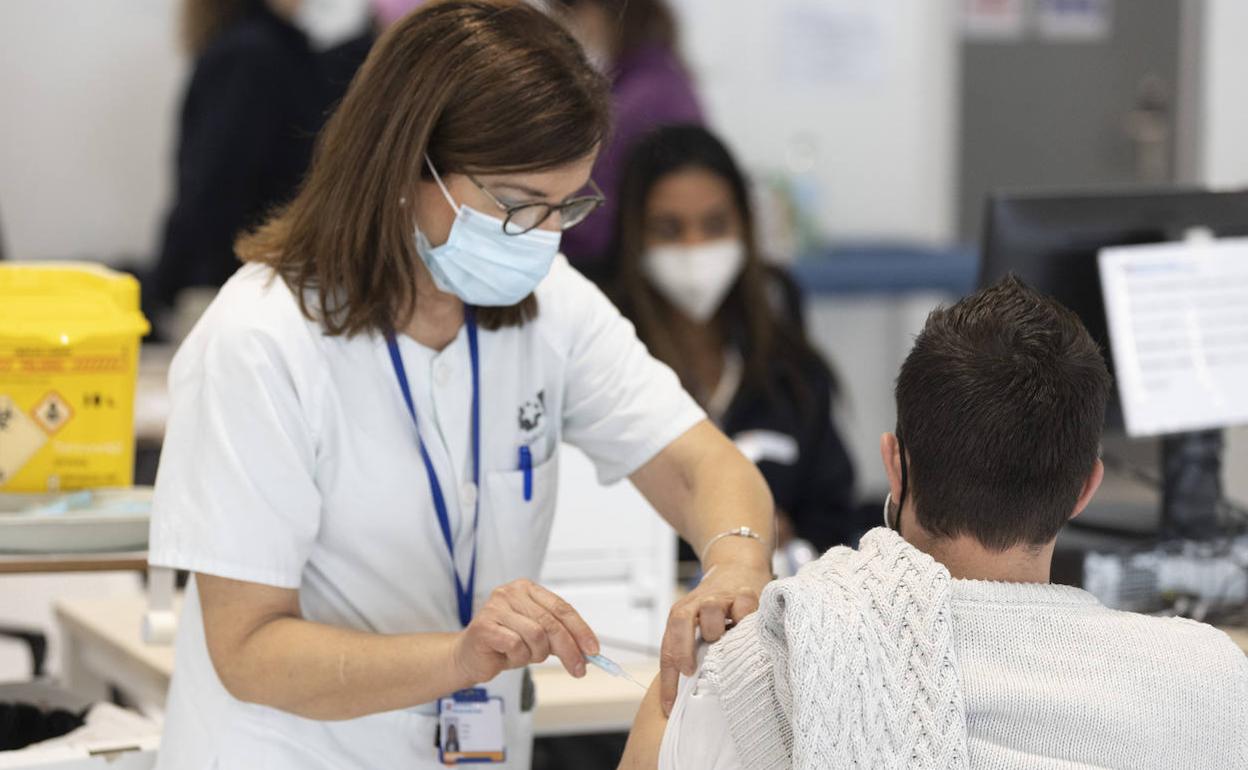 Sanitaria administra una dosis de la vacuna a un paciente. 