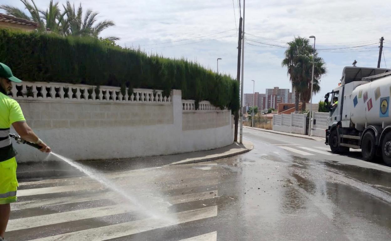 Un operario de limpieza realiza el baldeo de una calle de la ciudad