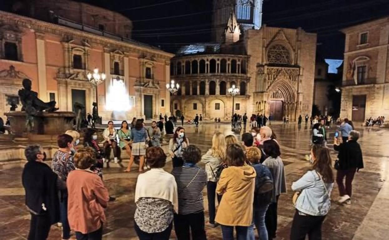 Turistas en una visita nocturna en la Plaza de la Virgen 