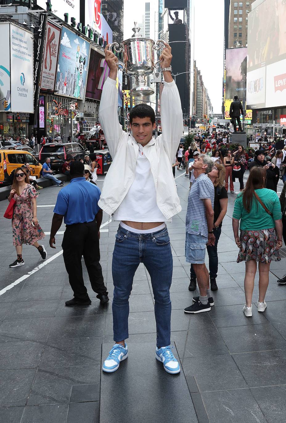 Carlos Alcaraz posa junto al trofeo del US Open en Times Square