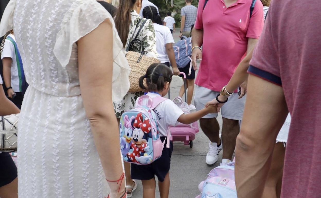 Unos padres llevan a su hija al colegio. 