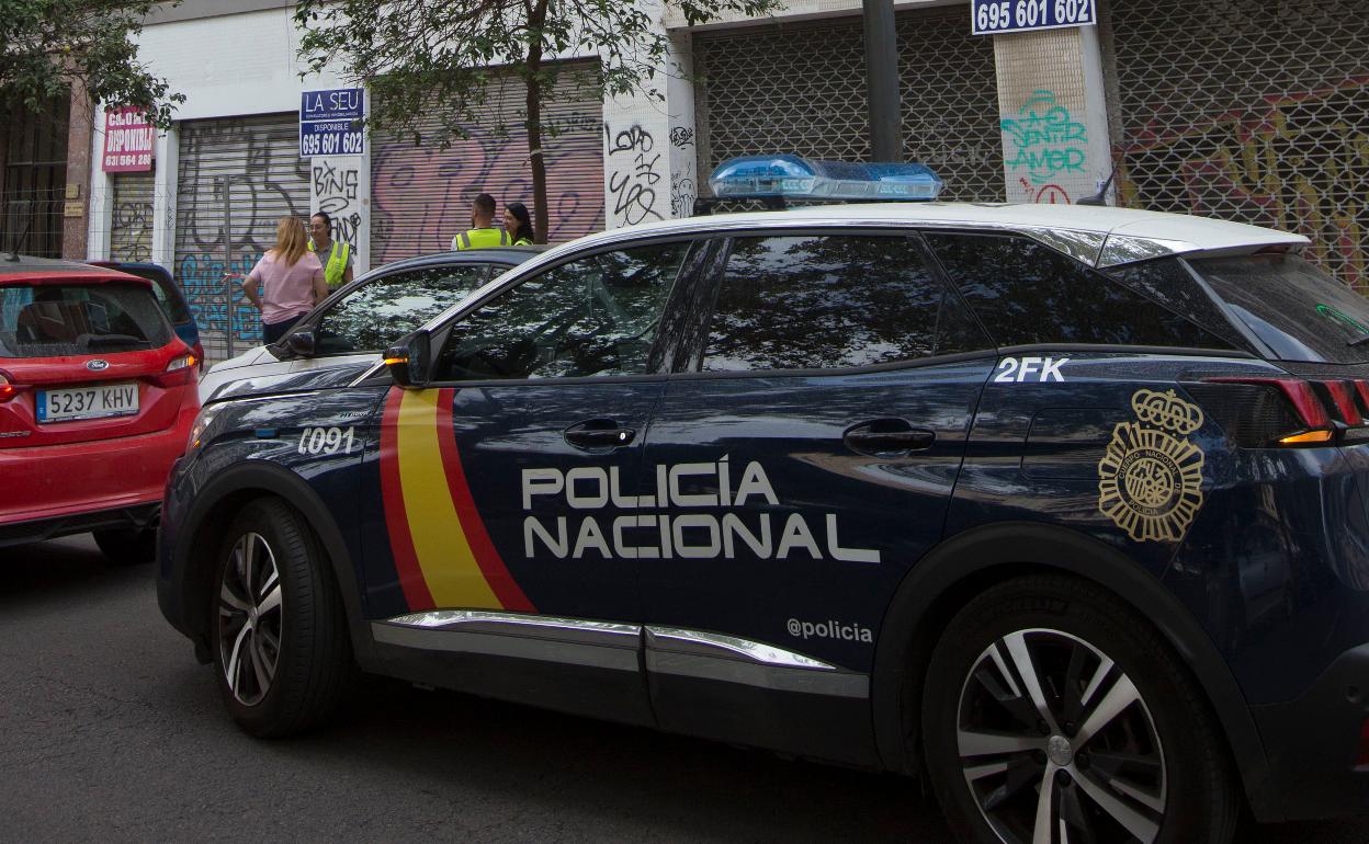 Un vehículo de la Policía Nacional estacionado junto al edificio donde ha ocurrido el trágico suceso. 