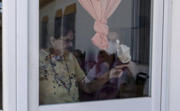 Dos mujeres miran por una ventana. 