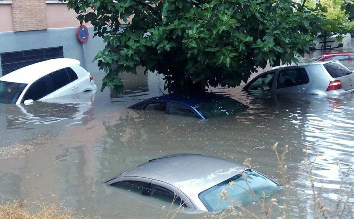 Coches afectados por la fuerza de la corriente de agua tras las intensas lluvias