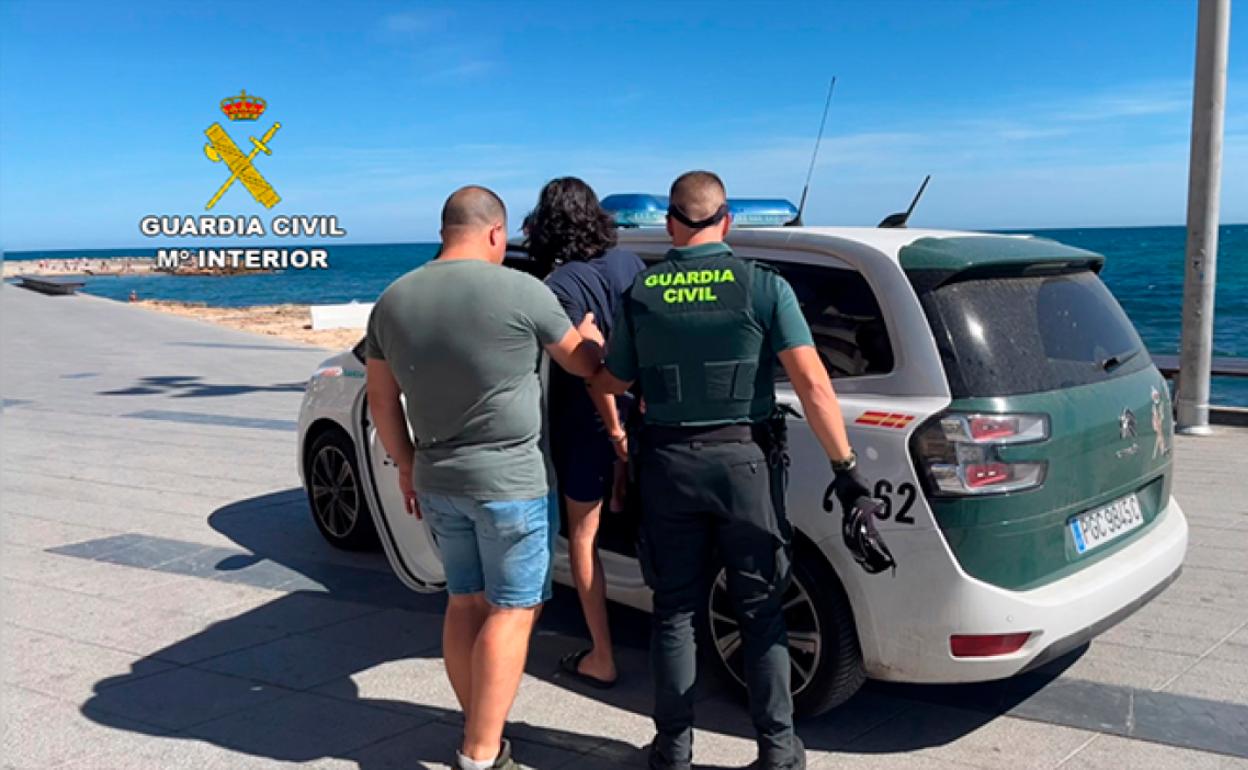 Uno de los detenidos es acompañado por dos miembros de la Guardia Civil. 