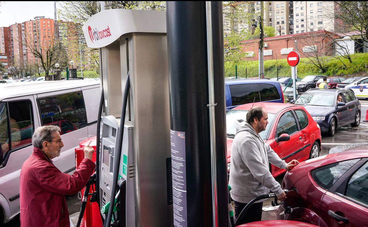 Unos clientes repostando en una gasolinera.