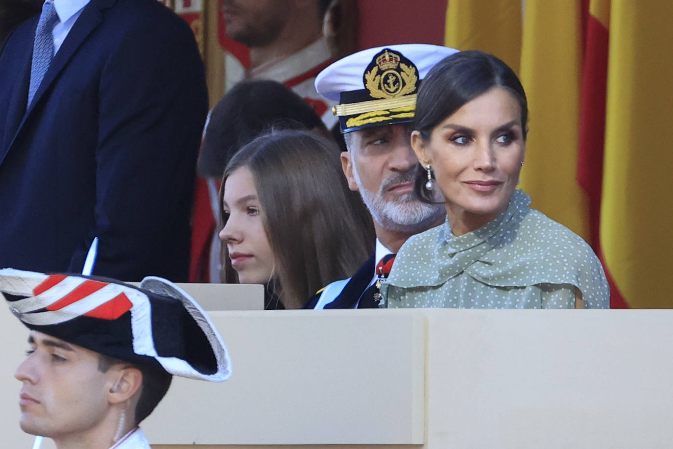 La reina opta por un vestido de gasa en verde con lunares blancos de la firma española Vogana. Se trata del modelo Nanda, de la colección del año 2021, con un precio de 265 euros. En la pieza de silueta fluida y cintura marcada destacaban las originales mangas, con una abertura que dejaba ver discretamente sus torneados brazos y formadan una suerte de capa. Menos discretos son los espectaculares pendientes de perlas australianas que le regaló don Felipe hace más de una década, con los que completó el estilismo.