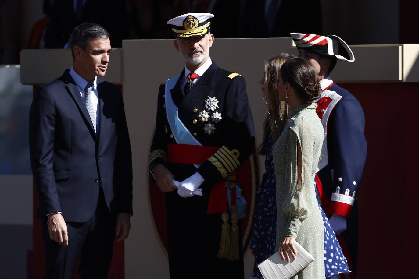 La reina opta por un vestido de gasa en verde con lunares blancos de la firma española Vogana. Se trata del modelo Nanda, de la colección del año 2021, con un precio de 265 euros. En la pieza de silueta fluida y cintura marcada destacaban las originales mangas, con una abertura que dejaba ver discretamente sus torneados brazos y formadan una suerte de capa. Menos discretos son los espectaculares pendientes de perlas australianas que le regaló don Felipe hace más de una década, con los que completó el estilismo.