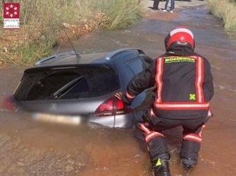 Fotos: Los bomberos rescatan a una mujer atrapada en su coche hundido en un socavón en Onda