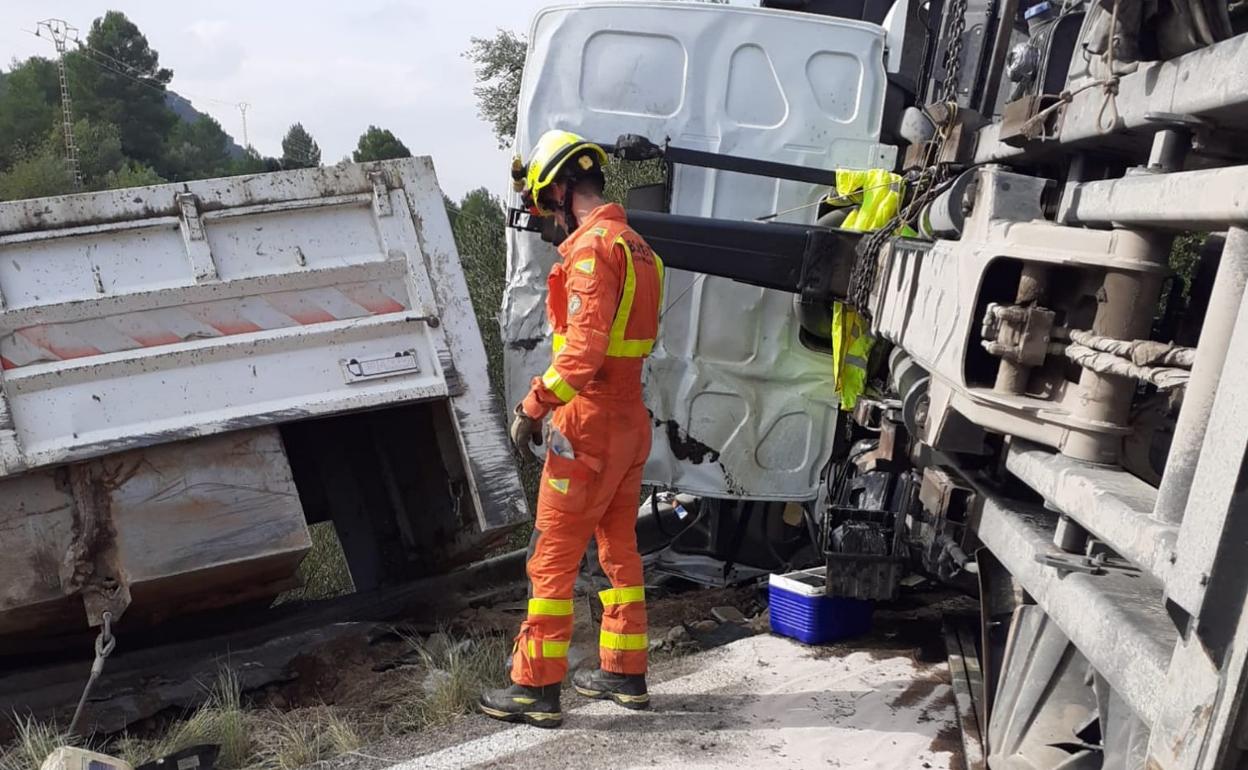 Los bomberos han tenido que utilizar una grúa para poder liberar al conductor del camión.