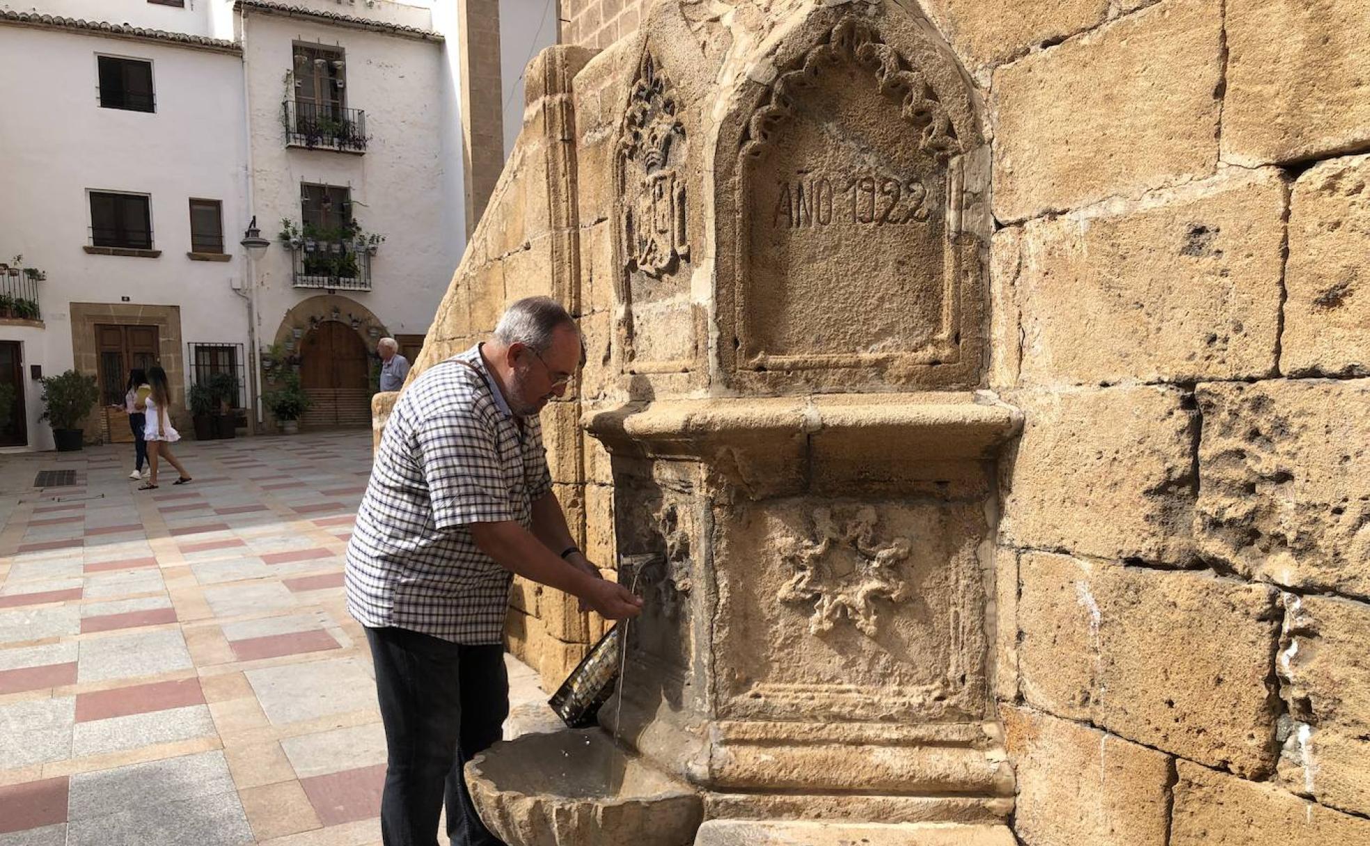 Antoni Espinós, lavándose las manos en la fuente centenaria de la plaza de la Iglesia. 