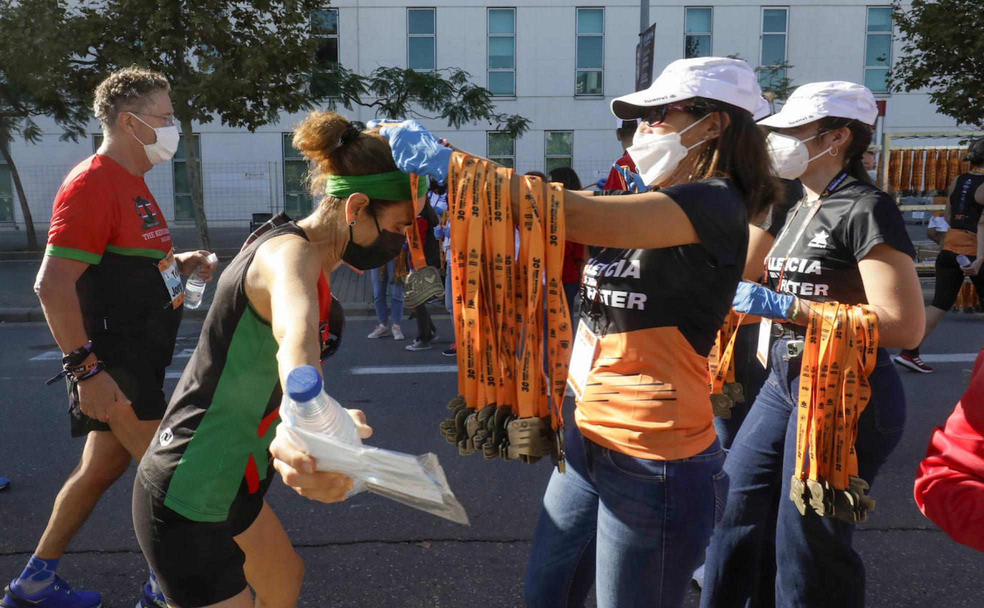 Una atleta recibe con orgullo la medalla de finisher del Medio Maratón de Valencia de la edición de 2021. 