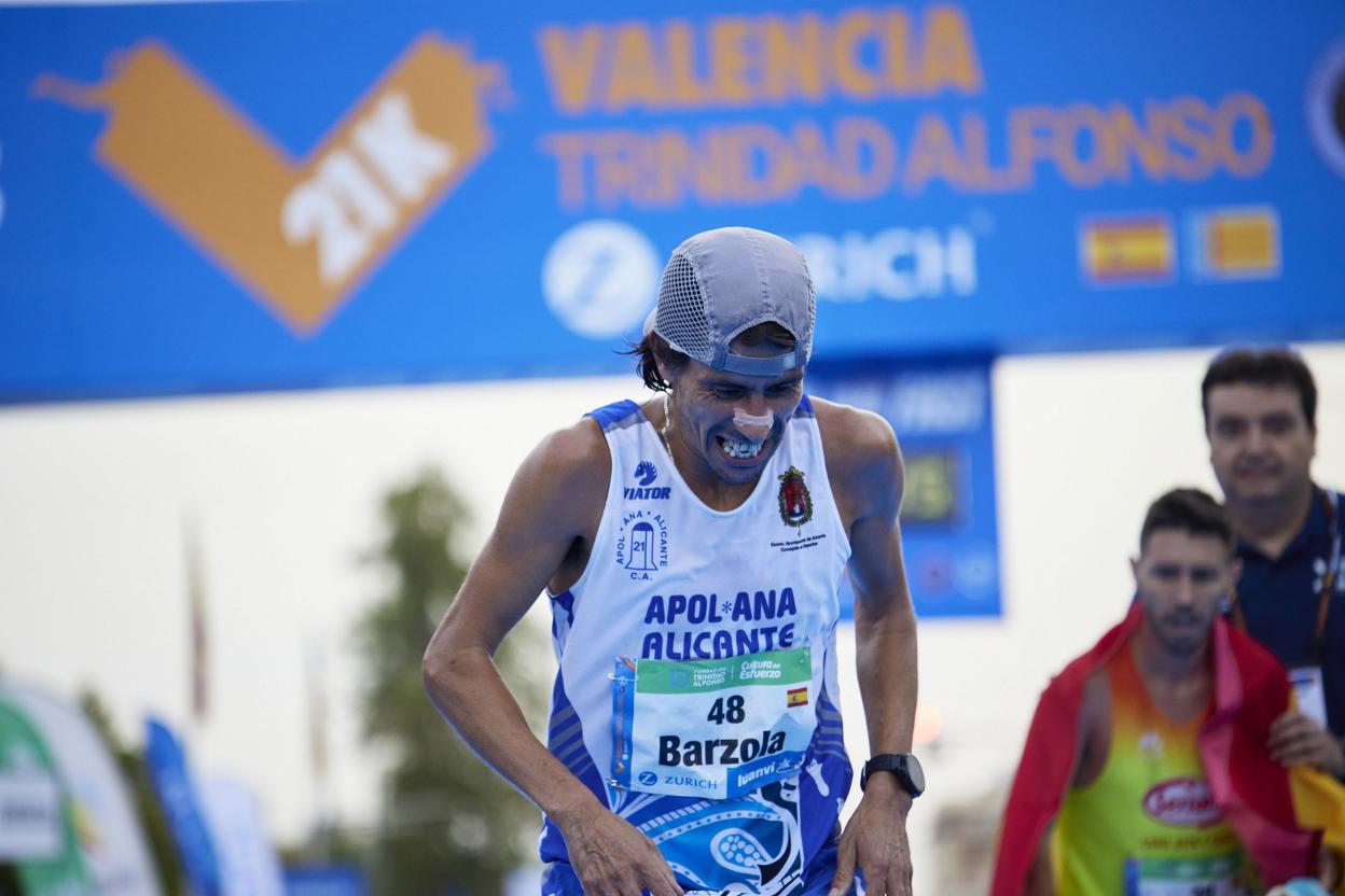 Barzola llega a la meta del Medio Maratón con Chiki detrás enfundado con la bandera española. 