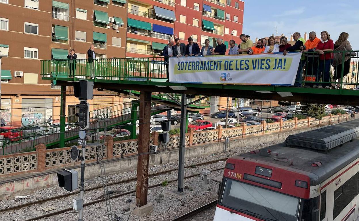 Carlos Mazón y el alcalde, Juan Ramón Adsuara, cuelgan una pancarta en la pasarela. 