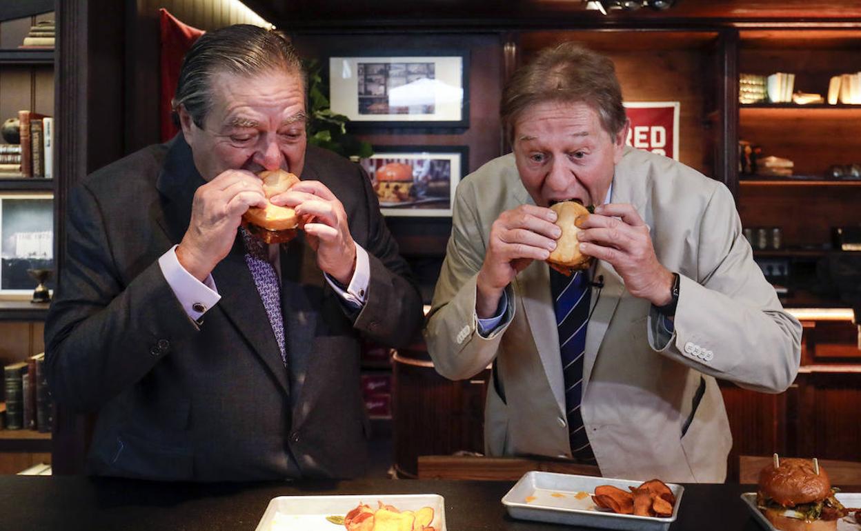 Vicente Boluda y Javier Quesada degustan la hamburguesa Jaume's durante la presentación de la propuesta. 