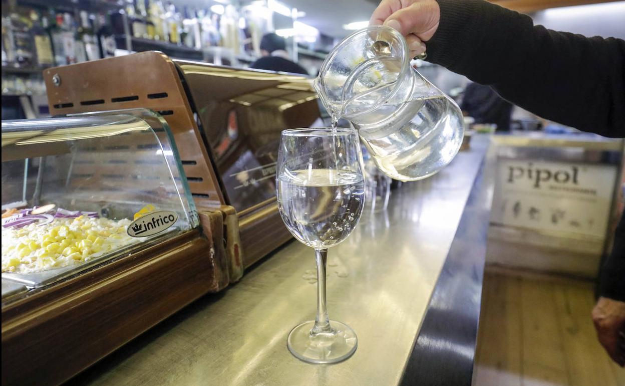 Un camarero sirve agua en un bar de Valencia.