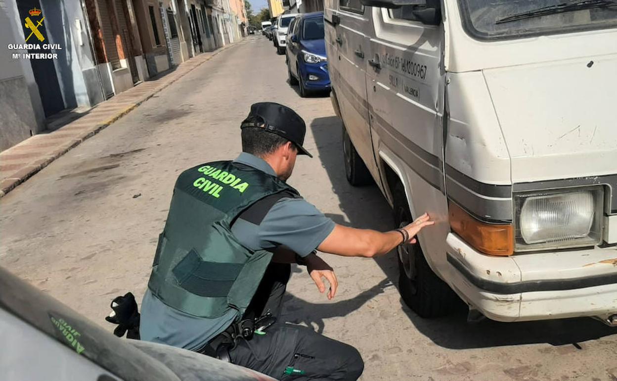 Un agente de la Guardia Civil comprueba los daños ocasionados en una furgoneta. 