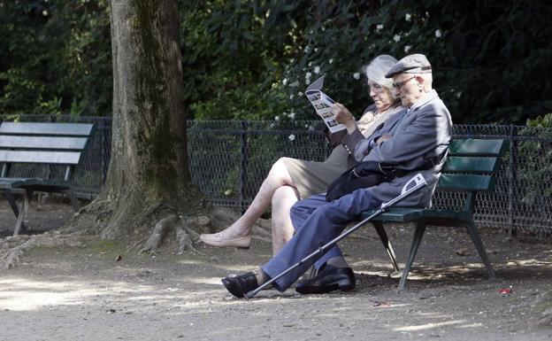 Dos jubilados, sentados en un parque. 