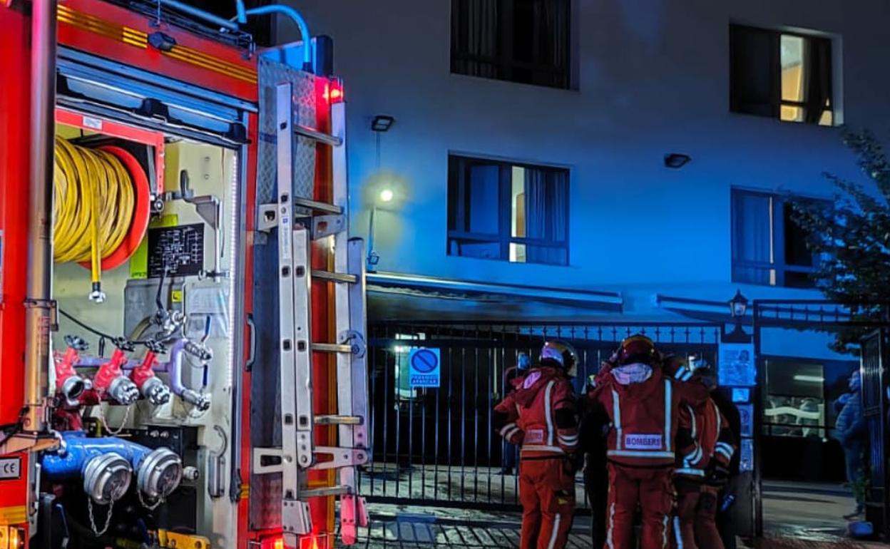 Un grupo de bomberos en la puerta del centro donde se ha registrado el incendio. 