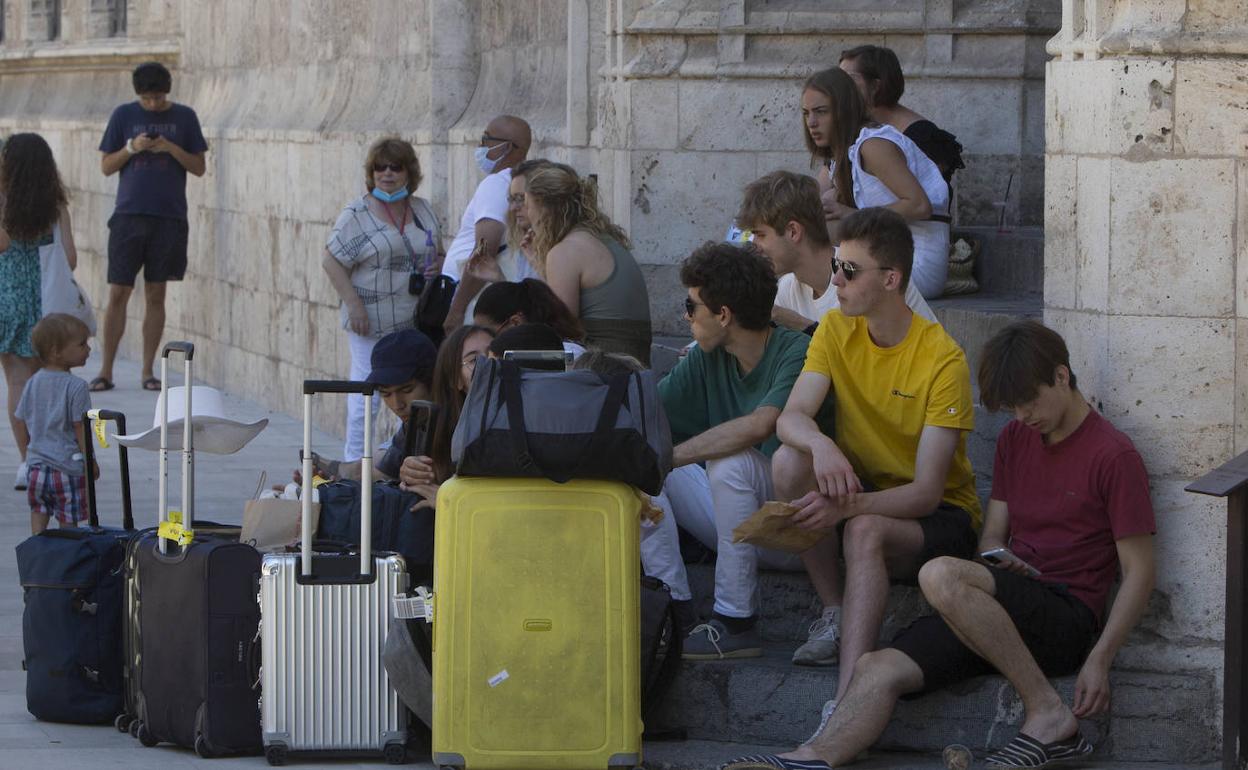 Un grupo de turistas junto a la Lonja el pasado verano. 