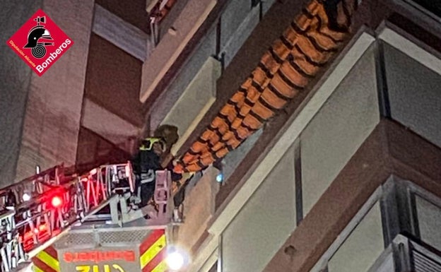 Los bomberos retiran un toldo caído en Benidorm. 