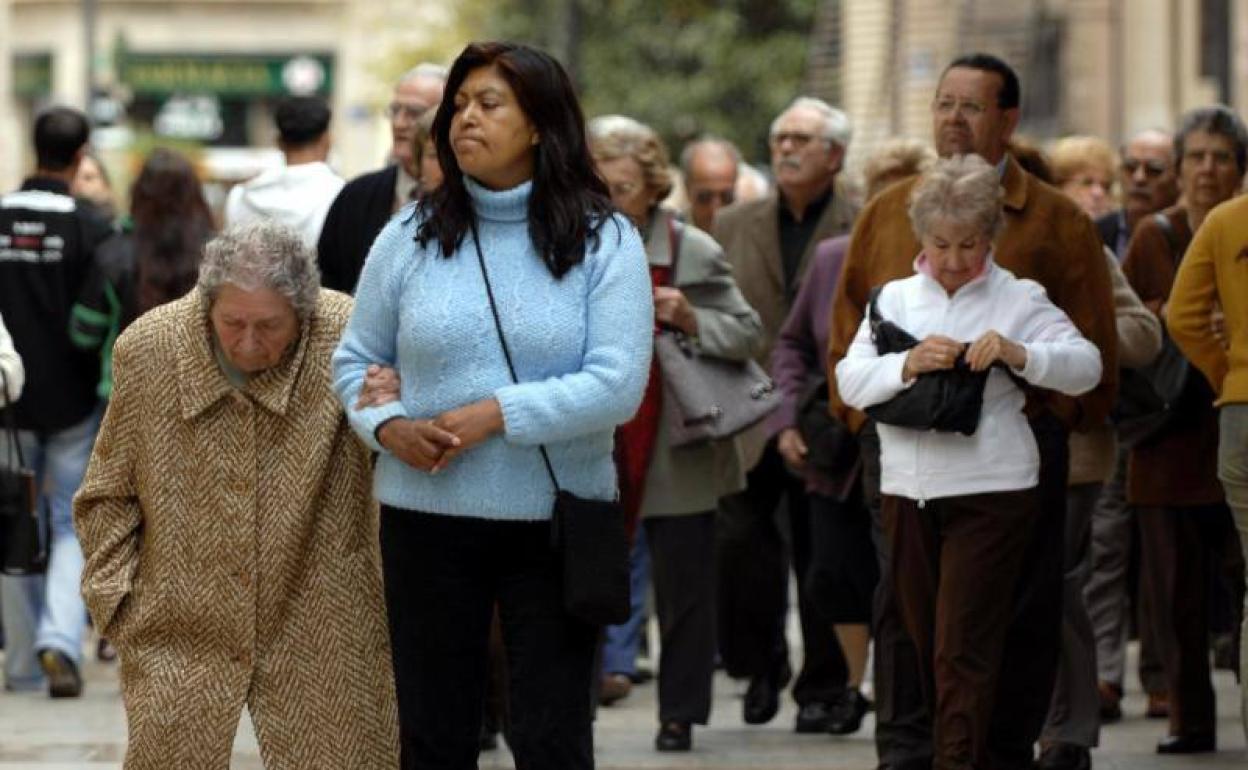 Una mujer, acompañando a una persona mayor. 