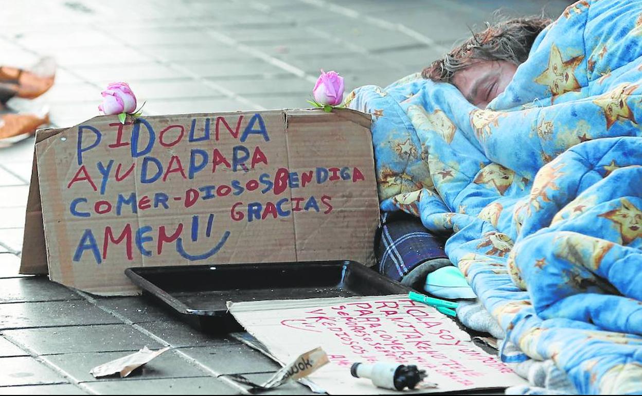 Un indigente pide limosna en el centro de Valencia.