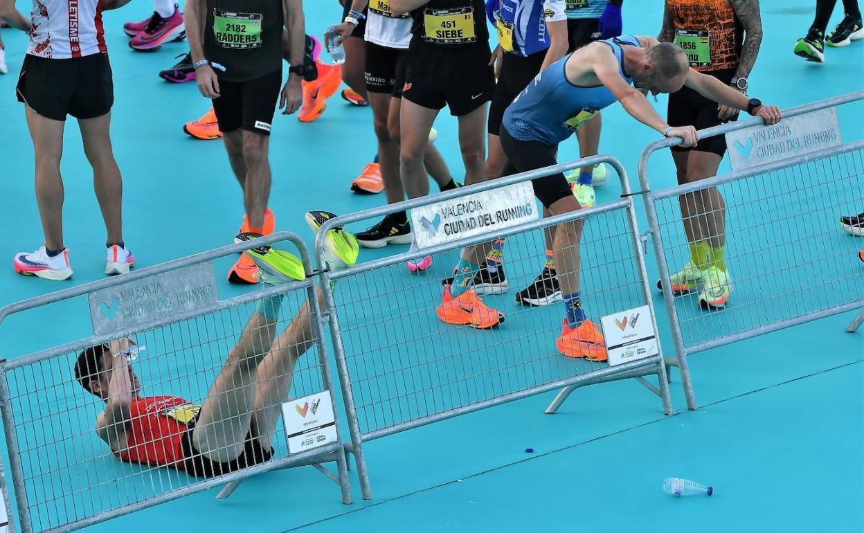 Participantes en el Maratón Valencia Trinidad Alfonso, estiran tras la disputa de la prueba. 