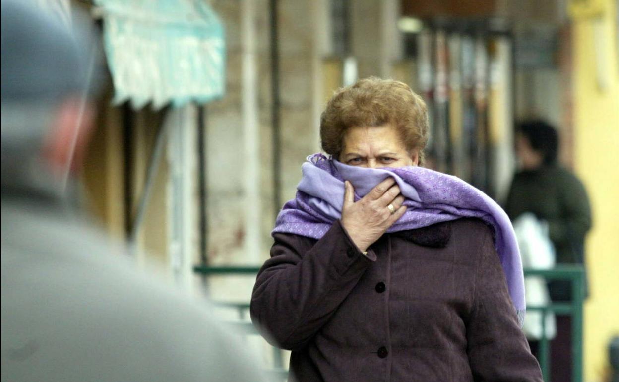 Una mujer se cubre con una bufanda para protegerse del frío
