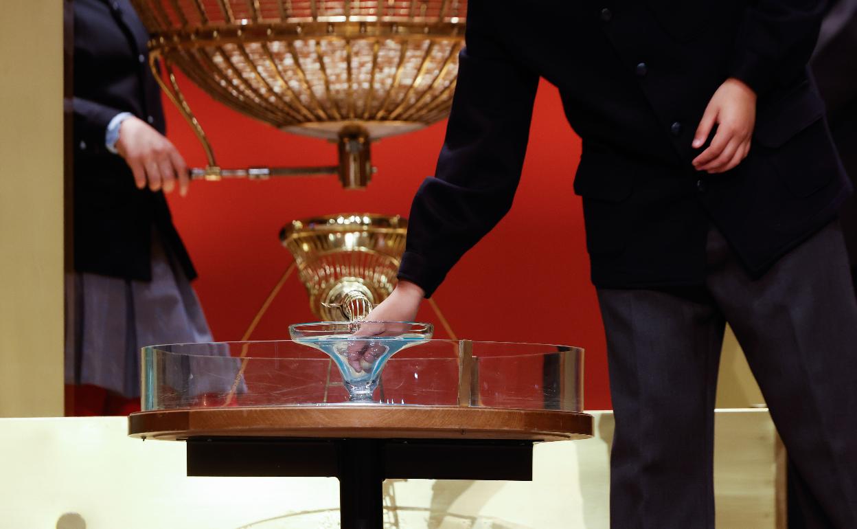 Uno de los niños coge una bolita del bombo de los números durante el sorteo. 