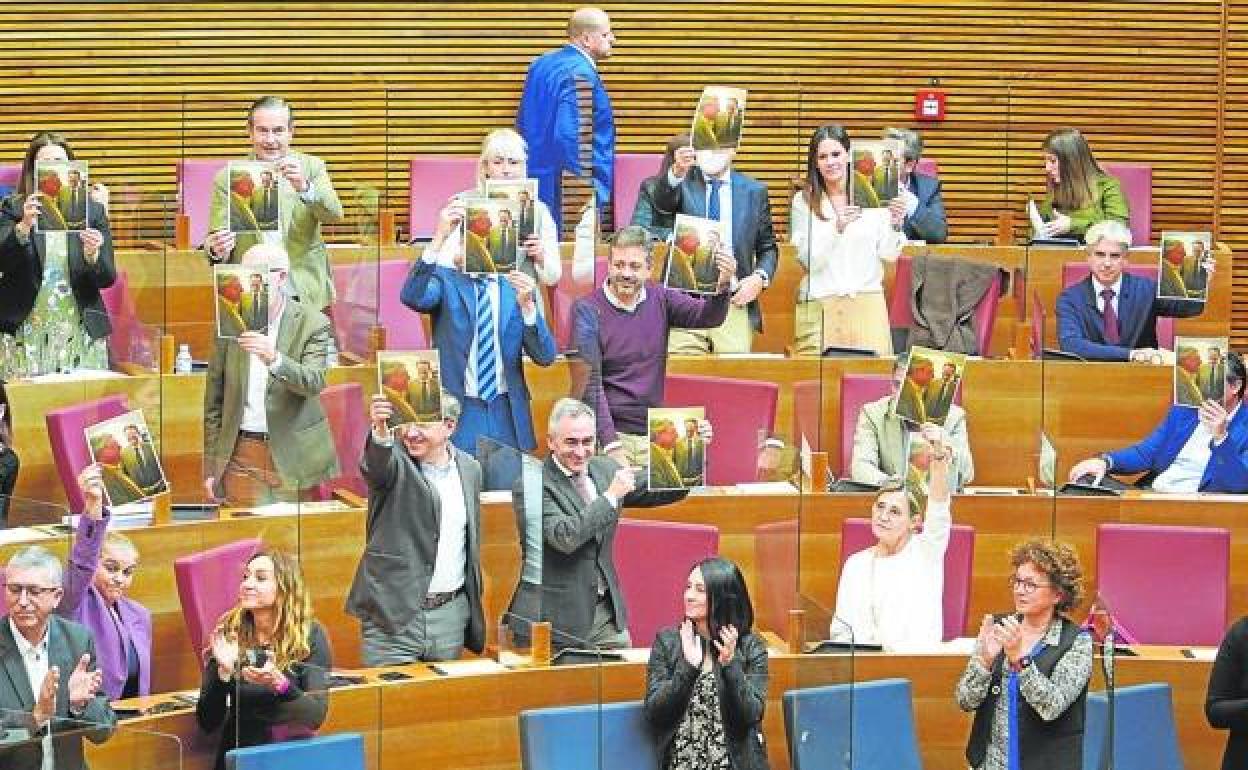 Diputados del PP muestran una foto de Cataluña con Ximo Puig en Les Corts. 