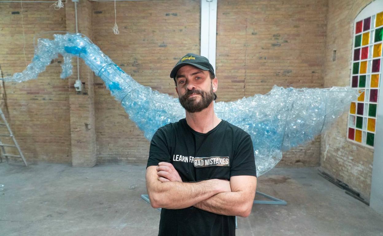 El artista David Moreno, con la escultura realizada con plásticos reciclados. 