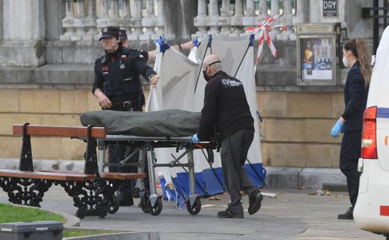 Agentes de la Ertzaintza y de la Policía científica inspeccionan el cuerpo de la víctima. 