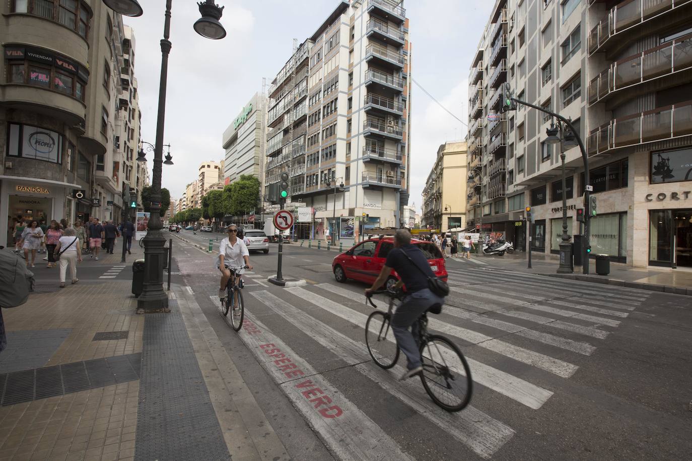 Ciclistas, peatones y coches en la calle Colón de Valencia.