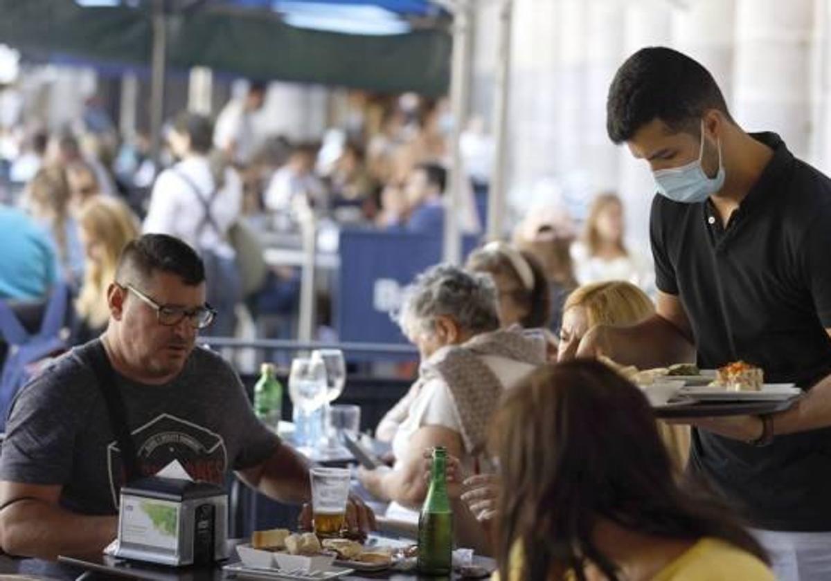 Un camarero atiende a una mesa en un restaurante.