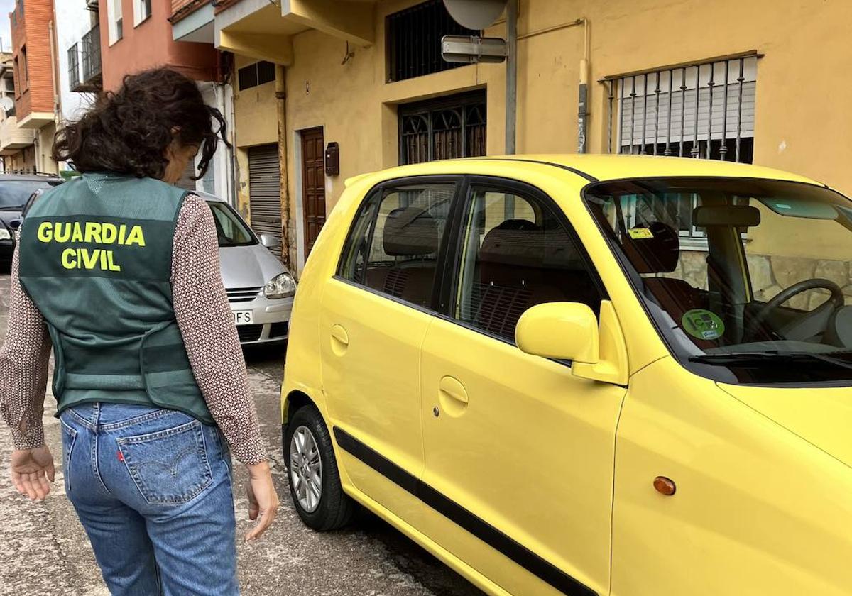 Una agente observa el vehículo.