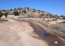 Un riachuelo de líquido oscuro y fétido sale de la montaña de residuos.