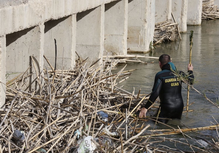 Un agente de la Guardia Civil especializado en medios acuáticos busca a Marta Calvo en el río Albaida, durante los rastreos de la joven desaparecida.