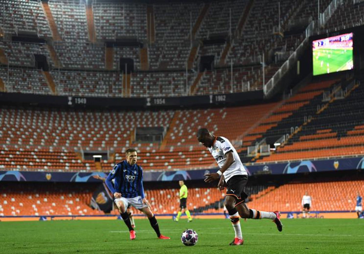 Kondogbia a punto de golpear el balón ante la Atalanta en Champions con Mestalla vacío.